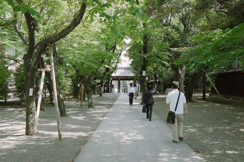 Business men leaving after a moment of serenity at Yasukuni shrine.