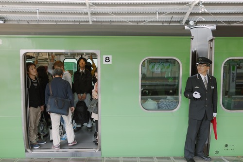 An attendant readies a train to leave Yoyogi station.