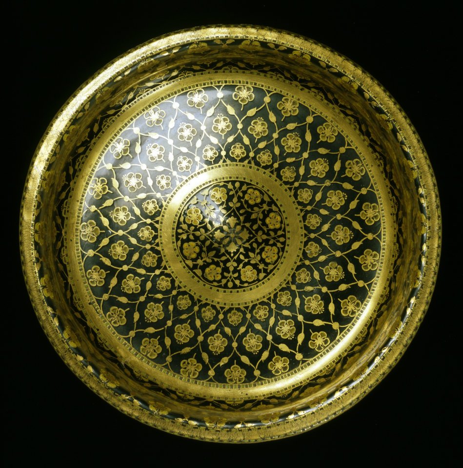 Dish, colorless glass, decorated with enamel and gilded. India, Mughal; c. 1700. The flowers on the dish were contoured on the inside with gold and filled in with red and yellow enamel, while the outside was painted solely in yellow. This produces a kind of three-dimensional effect that is characteristic of Mughal glass art with painted decoration. Photo: The David Collection