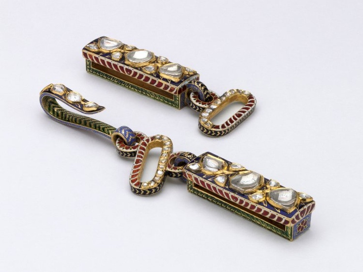 Mughal gold and enamel belt buckle in two pieces with inlaid diamonds. Enamel decoration on reverse of tiger attacking a boar.   b. Rectangular element with small round ring through which oblong ring fits. Hook is attached to this. Enamel tiger attacking a deer in foliage on reverse of rectangular element. British Museum