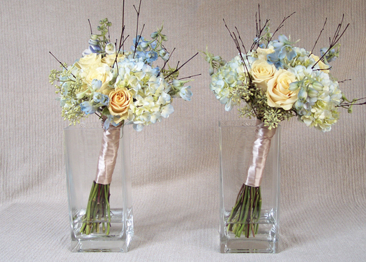 hand tied bridesmaids bouquets with Cream Prophyta roses, pale blue hydrangea, light blue delphinium, seeded eucalyptus, and bamboo