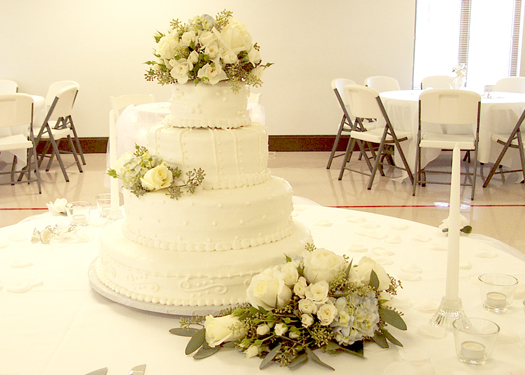 wedding cake with Blizzard roses, white spray roses, pale blue hydrangea, and seeded eucalyptus