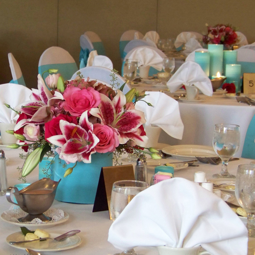 Low tiffany blue and pink centerpiece with a tiffany blue candle centerpiece in the background