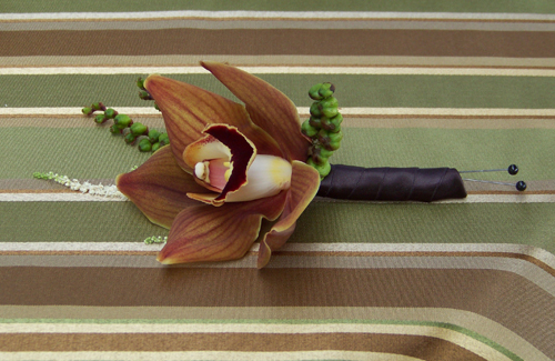 boutonniere with a chocolate cymbidium, montbretia pods and astilbe