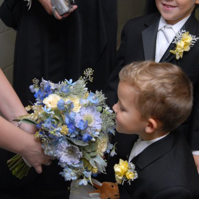 the ring bearer smelling the bridal bouquet