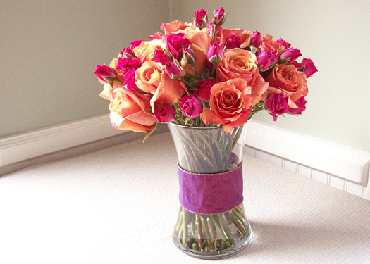 a wide band of ribbon pulls the arrangement of Milva roses and hot pink spray roses together
