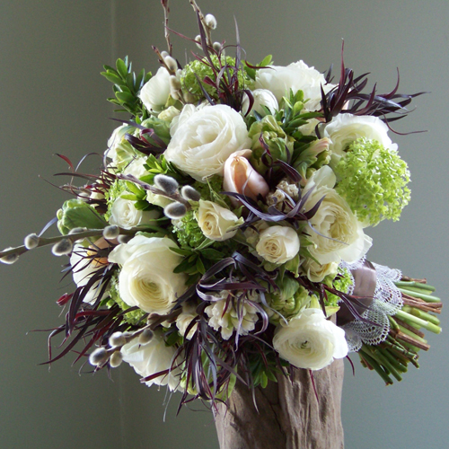 bouquet with bright green viburnum, white hyacinth, peach Menton French tulips, green parrot tulips, white ranunculus, French pussy willow, Snow Dance spray roses, euonymus foliage and deep purple agonis