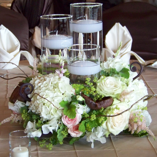 floating candle centerpiece with white sweet peas, white hydrangea, Green Fashion roses, blush astilbe, Star Blush spray roses, ixia, alchemilla, bupleurum, scented geranium, curly willow, badam nuts and fern curls