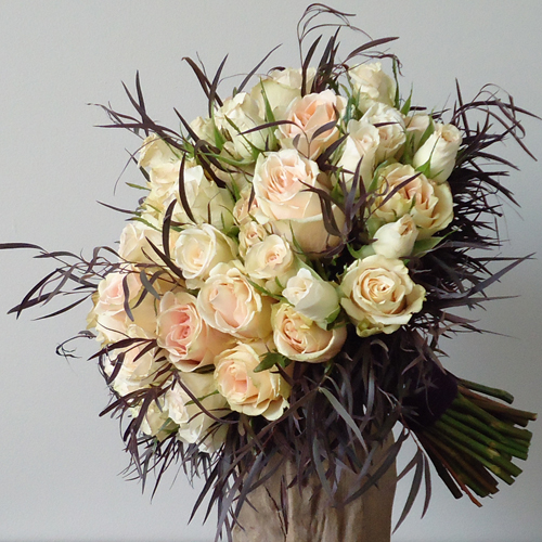 hand tied bouquet with High & Arena roses, Porcelina spray roses, and agonis