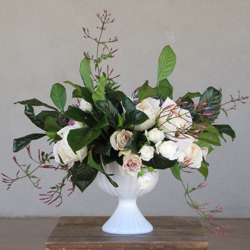 centerpiece with Lavande and Metallina roses, jasmine vine, Wendy spray roses, Helga Piaget garden roses and gardenia foliage, arranged in a vintage milk glass compote