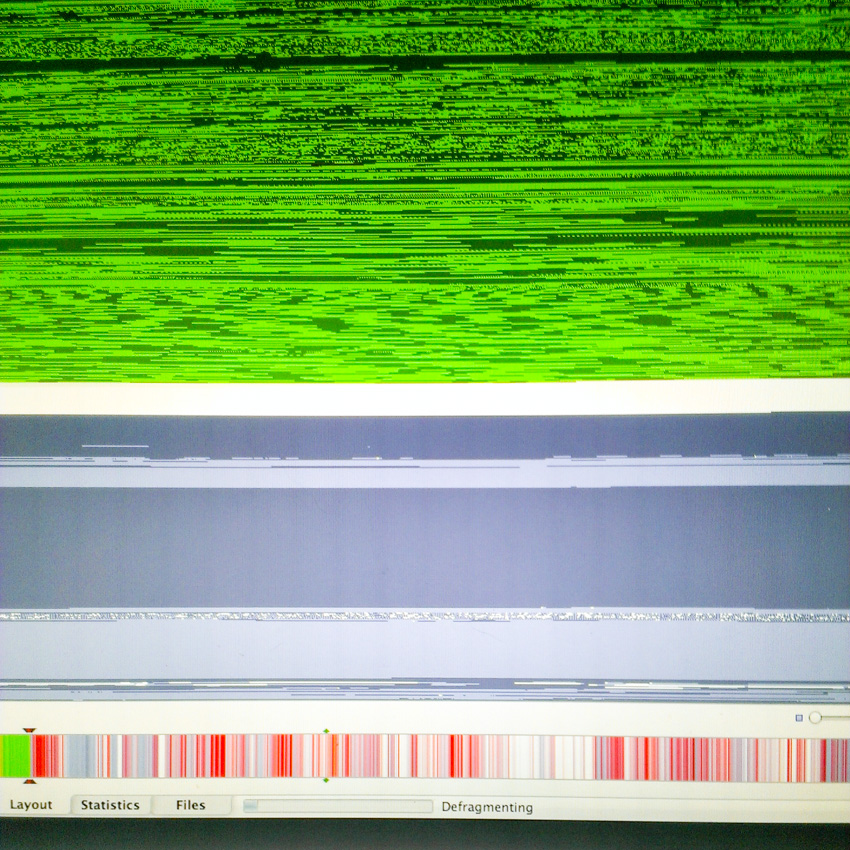 This is the iDefrag layout view of my early 2008 MacBook Pro's hard drive blocks just as I started the defragmentation process. The horizontal strip near the bottom, with red stripes in it, is a single look at the entire drive. Red stripes indicate fragmented files across the drive.