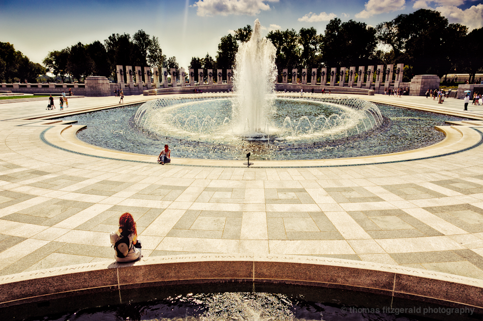 A Girl sits observing the fountain in the World War II Memorial, Washington DC. 