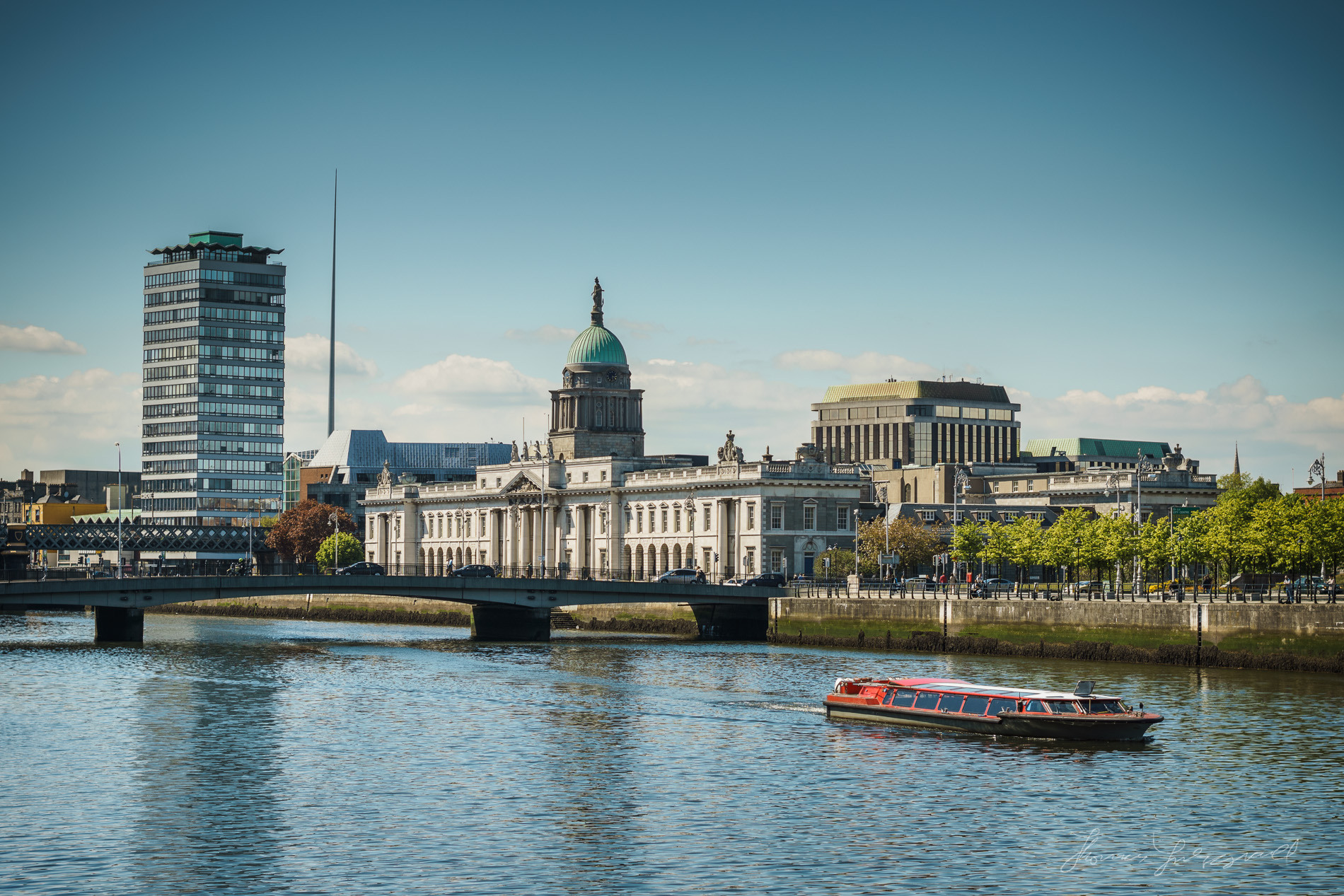 A tourist boat travels along the river liffey