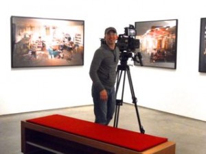 Luc films the photographs in Lori's show at ClampArt.