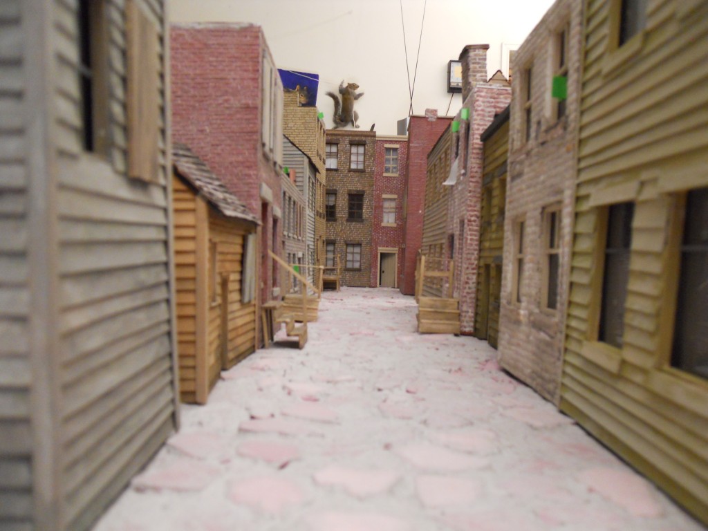Early stage of alley. Buildings are all scratch-built. A rare, hovering giant squirrel looms in the distance.