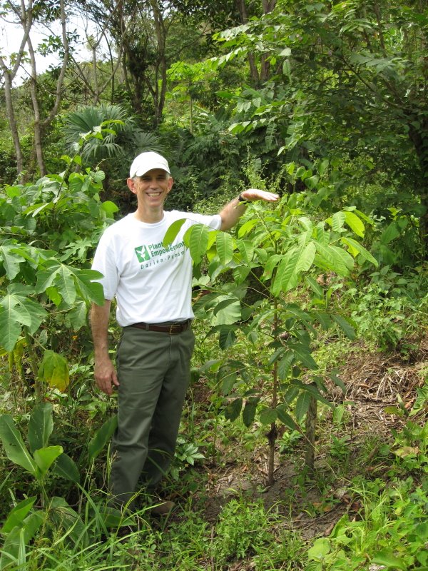 Photo: An investor stands with a young mahogany tree during Planting Empowerment's first investor trip in 2008
