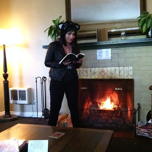 Smiling and taking a power stance as I read to a living room full of people about a woman who has to mutilate her own leg in order to escape a crumbling building. I'm pretty sure I don't always smile when I read about morbid shit. Photo by punk rock artist Chrissy Horchheimer.