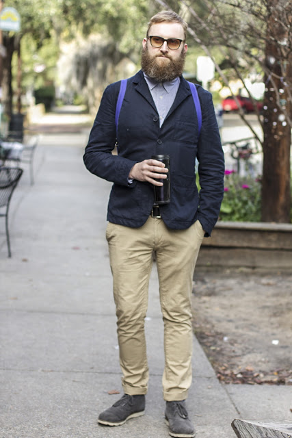 Dean Sidaway, SCAD Fashion Design Faculty, wears a three button navy blazer over a lighter blue shirt and rolled-up khaki pants  and gray suede boots.