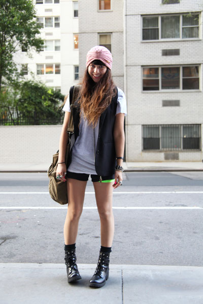 NYU student Shea Daspin wears a turban head accessory, a sleeveless blazer vest over an off white t-shirt and black short shorts and black canvas boots